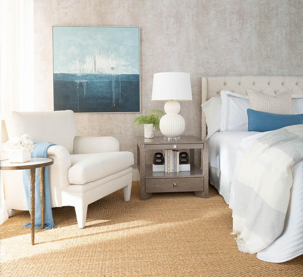 A woven rug compliments a room with traditional furniture that is accented with modern touches. Gentle blue accents provide a beachy feel.